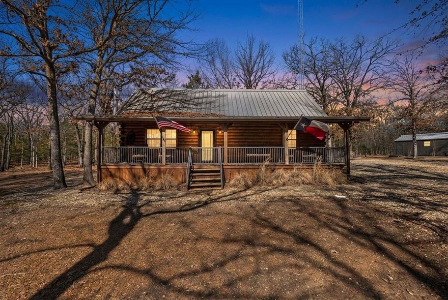 Tucked away on 4.2 heavily wooded acres, this charming country cabin is the kind of place you come to slow down, unplug, and breathe. Set on a quiet paved county road, it feels worlds away from the city—yet easy to get to—making it ideal as a full-time residence, weekend escape, or proven vacation rental.  The exterior sets the tone with a classic log-style design, a top-of-the-line standing seam metal roof, and a massive back porch that’s made for rocking chairs, morning coffee, and watching the sun dip below the trees. At night, the stars put on a show you just don’t get in town.  Inside, the cabin is warm, inviting, and full of character. The vaulted living room ceiling and wood-burning stove create a cozy lodge feel, perfect for cool East Texas evenings. The open layout flows easily into a well-appointed kitchen with rustic cabinetry and modern appliances, making it just as functional as it is charming. Two comfortable bedrooms and one full bath provide everything you need without excess—simple, efficient, and peaceful.  Outside, the property continues to impress with a storage shed and a large additional building that could serve as a shop, hobby space, or extra storage. The wooded acreage offers privacy, wildlife, and endless possibilities for trails, gardens, or simply enjoying nature.  This property can be purchased fully furnished, including a lawn mower, for a little more—making it truly turnkey whether you plan to Airbnb it, use it as a vacation home, or make the permanent move to country living.  If you’ve been dreaming of a place where life feels quieter, nights are darker, and nature surrounds you—this one delivers.  Additional Acreage available