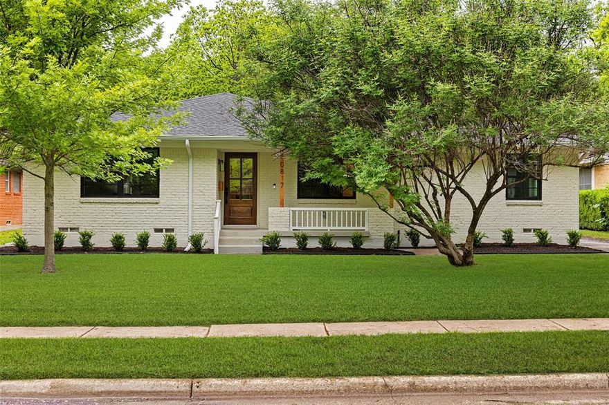Beautifully reimagined by Maverick Design, this charming East Dallas home blends timeless character with modern design in a prime location near White Rock Lake. The inviting painted brick exterior, mature trees, and manicured landscaping create exceptional curb appeal, while inside you’ll find a light-filled, open-concept layout with wide-plank wood floors and a cohesive designer finishes throughout. The stunning kitchen features a large island, quartz countertops, custom cabinetry, stainless steel appliances, and seamless flow into the living and dining areas—perfect for entertaining. A cozy fireplace anchors the living space, complemented by built-ins and easy access to the backyard. The spacious primary suite offers a spa-like bath with dual vanities, oversized glass shower, and elegant finishes. Secondary bedrooms and baths are equally well-appointed with updated fixtures and neutral tones. A dedicated utility room adds convenience and storage. Enjoy indoor-outdoor living with a private backyard and patio space ideal for relaxing or hosting. Nestled within the verdant canopy of Lochwood, this home offers style, comfort, and an unbeatable Dallas address close to parks, dining, and shopping.