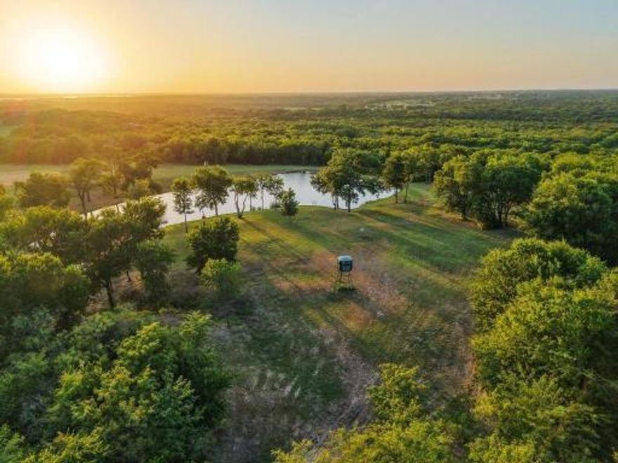 Experience true North Texas privacy on this secluded 20.7-acre retreat overlooking the Hagerman Valley. Designed for those who value space, freedom, and the ability to enjoy the outdoors without ever leaving home, this property offers a lifestyle most people only dream about. Hunt from the back porch at sunrise, ride ATVs through the wooded trails, or watch the kids fish in the stocked hilltop pond just steps away at sunset.
This peaceful country oasis is located in Pottsboro ISD, just minutes from several Lake Texoma marinas and only 10 minutes from Sherman and Denison. The property is within biking distance of Hagerman Wildlife Refuge and offers convenient access to multiple nearby casinos. It’s also a premiere destination for family gatherings and effortless entertaining.
The land features a mix of open pasture and wooded acreage, with a scenic pond adding both charm and utility. Whether you envision a hunting ranch, homestead, or retreat property, the layout supports a wide range of uses.
The structure itself is exceptionally well built, offering five potential bedrooms and a semi-commercial kitchen. Three 16x8 full-view glass doors lift to the ceiling, opening the interior to a massive porch and panoramic views of the surrounding landscape. The thoughtful design provides outstanding flexibility in how the space can be used. Multiple prime build sites across the property offer opportunities for a primary residence with breathtaking views, and the existing barn can be preserved as a luxury guest house or private event space.
This property was created with versatility in mind—whether envisioned as a hunting ranch, farm, Airbnb retreat, private homestead, or venue. It serves as a premier setting for gatherings and long-term growth, offering the foundation for a lasting legacy in North Texas. Schedule your tour today.