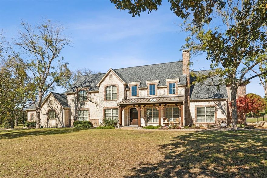 Stunning updated custom home that exudes timeless elegance in coveted Oakwood Estates. Surrounded by mature trees and situated on a cul-de-sac on a park-like 1.5 acres of land, enjoy country living in exemplary Lovejoy ISD only minutes away from every amenity available. This home is an entertainer’s dream with 4 living and 2 dining areas. As you enter, the elegant, curved staircase draws your eye to the 2-story formal living room with a majestic wall of cut stone that is a focal point of this luxurious room that also features a gas fireplace with a natural mantle. The state-of-the-art kitchen features a Viking 6 burner gas double oven, large breakfast bar and island, with a 2nd staircase leading to the upstairs. Just off the kitchen is breakfast area and a butler's pantry with a wine fridge, fridge, and lots of cabinet and counter space that adds extra convenience while entertaining. Rustic hand-hewn beams and richly stained hand scraped hardwood floors are continuous throughout the living areas offering a unified feel. The primary suite boasts vaulted ceilings with hand hewn beams, stone fireplace, sitting area, and a deluxe ensuite with dual vanities, soaking tub, walk-in sauna shower, and has a massive walk-in closet. Secondary bedrooms have ensuites and large walk-in closets. There is a second primary upstairs with a balcony overlooking the resort style backyard. Privacy & nature abound in this luxurious home with a backyard that is fenced for pets and children and features a sparkling pool & spa, outdoor kitchen, and a cabana with a stone fireplace. The finishes and features of this home present an elegant and luxurious living that will provide your family with many happy memories!