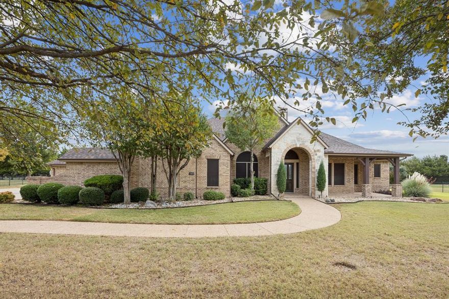 Experience Luxury, Comfort & Timeless Design in the Heart of North Texas! This stunning single-story, custom-built home sits gracefully on a one-acre lot offering privacy, sophistication & an inviting sense of home. Conveniently located near Allen, Murphy, Wylie & Plano, this residence blends luxury craftsmanship with everyday comfort—ideal for families, retirees, or multigenerational living. Step inside to discover a beautifully flowing floor plan enhanced by marble & hand scraped wood flooring, crown molding, new designer lighting & abundant natural light. The formal dining area & private home office with French doors set the tone for refined living, while two spacious living rooms with decorative gas log fireplace provide versatile spaces for both relaxation & entertaining.  The gourmet kitchen is a showpiece featuring granite countertops, stone backsplash, stainless steel appliances, gas cooktop, double ovens, walk-in pantry & a generous island perfect for gatherings. The expansive primary suite offers a peaceful retreat with a sitting area, dual vanities, jetted tub, separate shower & expansive walk-in closet with custom closet system. The bonus room adjacent to the primary bath serves perfectly as a nursery, home gym, yoga studio or second office. Secondary bedrooms & a media or flex space create a private wing for your growing family or guests, complete with a Jack-and-Jill bath & an additional full bath. This carpet free home also features a full-house air purification system. Epoxy-coated floors in four-car garage with insulated doors, garage door openers & extra storage. Enjoy evenings in the expansive backyard featuring lush green space. The large covered patio comes complete with Caldera saltwater hot tub. With fresh paint, new roof & gutters (2025), two newer water heaters (2023), Nest thermostats, Ring doorbell & Dogwatch invisible fence, this move-in-ready gem combines elegance with modern efficiency offering the best of North Texas luxury living.
