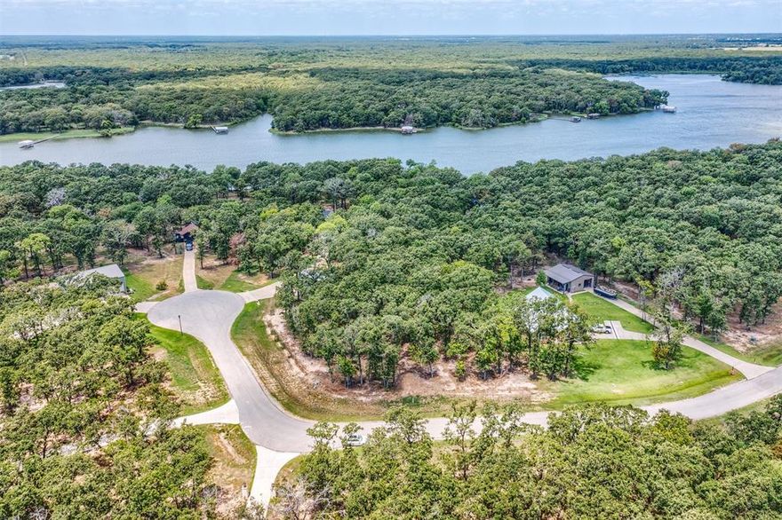 Escape the hustle and bustle of city life and embrace lakeside tranquility on this EXQUISITE ±2-ACRE LAKEFRONT LOT in the peaceful Nautical Shores community on Lake Tawakoni. This unique property offers exceptional flexibility with two distinct acres:

• Front acre (fee simple) allows a permanent structure, including a custom home or barndominium
• Second acre along the shoreline is an SRA (Sabine River Authority) leaseback, ideal for non-permanent structures and a floating dock, perfect for fishing, boating, swimming, and lake recreation. Need a Boat Slip while you build your personal boat dock? You have access to private boat slip for only $500 annually. Sabine River Authority Leaseback is approx $50 annually with an approved permit, SRA allows a pier up to 150ft & a boat dock. 

Surrounded by mature trees and natural beauty, the lot is nestled among quality homes in a quiet, established lake community. Deed restrictions preserve value (no mobile or modular homes). Minimum build requirements: 1,400 sq ft for one-story homes and 1,800 sq ft for two-story homes.
Nautical Shores features paved roads, streetlights, underground utilities, water and electric at the street, plus a private gated marina for residents. Large, lake-access lots like this are increasingly rare on Lake Tawakoni. Convenient access: approximately 60 miles to downtown Dallas, 40 miles to Rockwall, 20 minutes to Greenville for shopping, dining, and medical services, and just minutes to local marinas and public boat ramps. Savor the serenity, space, and versatility this property offers and make your lakefront lifestyle a reality. Lot is located between 2 lots: 6605 & 6657 Anchor Pt, Quinlan TX 75474. See private remarks for more info! Contact the listing agent directly if you have any questions.