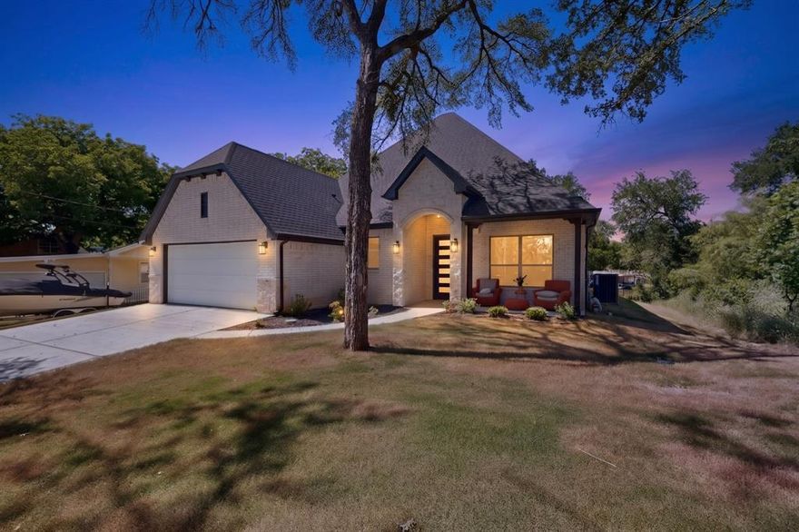 Discover this breathtaking 2025 semi-custom built 1.5-story waterfront home, perfectly nestled in the desirable Sky Harbour community on Lake Granbury. Boasting 72 feet of waterfront along a peaceful natural cove, this exceptional property offers quick boating access to the main body of the lake and an incredible opportunity to embrace the ultimate lake lifestyle. Spend your days cruising the water, fishing from your backyard, or entertaining lakeside with the option to add a private boat dock, while also enjoying access to the community boat dock. Thoughtfully designed with impeccable attention to detail, this stunning home showcases an exceptional floor plan ideal for both everyday living and unforgettable gatherings. Once inside, you’re welcomed by sweeping wood-look tile floors that flow throughout the main living areas. The light-filled living room is truly spectacular, featuring a sleek floor-to-ceiling stone gas fireplace, elegant coffered ceilings, and a dramatic wall of windows framing panoramic water views. The gourmet kitchen is designed to impress and fully equipped with stainless appliances, granite counters, under-cabinet lighting, and island, making it the perfect space for entertaining after a day on the lake. The primary retreat has a spacious walk-in closet and a luxurious ensuite bath featuring dual sinks, granite counters, a soaking tub, and separate shower. Two additional bedrooms share a beautifully appointed bath with dual sinks and granite counters. French doors lead to a home-office that could also be used as an additional bedroom. Upstairs, a versatile flex space with a full bath offers endless possibilities as a game room, bunk room, or additional guest retreat. With ample space to comfortably accommodate family and guests, this remarkable waterfront property is perfectly suited as a full-time residence, weekend escape, or short-term investment property. Experience the best of Lake Granbury living where every day feels like a vacation.