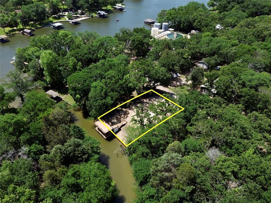 Exceptional waterfront homesite with 63 feet of shoreline on Cedar Creek Lake, located inside the gated Carolynn Estates community. This cleared lot is ready for your custom lake home and already features major improvements that are costly and time-consuming to duplicate. A 2023-built boathouse includes a covered slip with electric lift and an expansive upper-level party deck designed to capture beautiful water views. The channel was dredged during construction, and a steel retaining wall has been installed along the shoreline for long-term stability and shoreline protection. The lot offers a gentle slope toward the water, creating an ideal elevation for a future home with strong sight lines to the lake. With utilities available and survey on file, much of the preliminary work is already complete. Carolynn Estates is a gated waterfront community featuring a private boat ramp, fishing dock, park, community center, and abundant wildlife throughout the natural preserve setting. Located on the southeast side of the lake, this property offers peaceful surroundings while remaining within convenient driving distance to town amenities. If you’re looking for waterfront property where the heavy lifting has already been done, this is a strong opportunity!