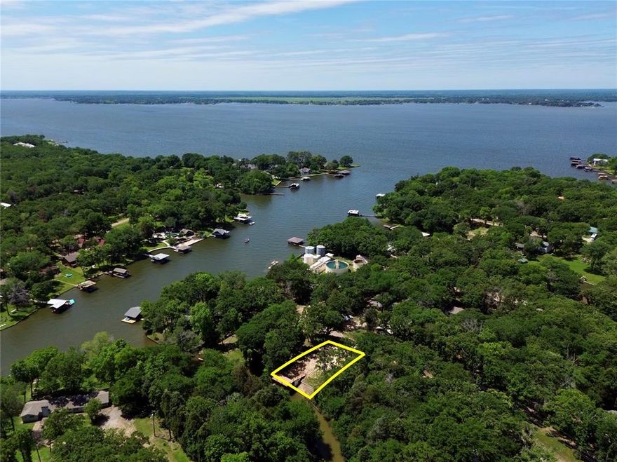 Exceptional waterfront homesite with 63 feet of shoreline on Cedar Creek Lake, located inside the gated Carolynn Estates community. This cleared lot is ready for your custom lake home and already features major improvements that are costly and time-consuming to duplicate. A 2023-built boathouse includes a covered slip with electric lift and an expansive upper-level party deck designed to capture beautiful water views. The channel was dredged during construction, and a steel retaining wall has been installed along the shoreline for long-term stability and shoreline protection. The lot offers a gentle slope toward the water, creating an ideal elevation for a future home with strong sight lines to the lake. With utilities available and survey on file, much of the preliminary work is already complete. Carolynn Estates is a gated waterfront community featuring a private boat ramp, fishing dock, park, community center, and abundant wildlife throughout the natural preserve setting. Located on the southeast side of the lake, this property offers peaceful surroundings while remaining within convenient driving distance to town amenities. If you’re looking for waterfront property where the heavy lifting has already been done, this is a strong opportunity!