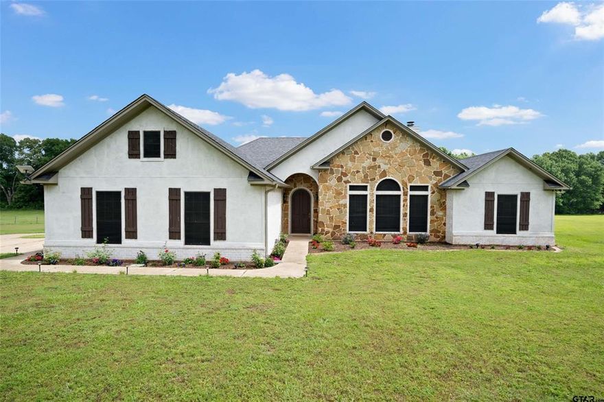 Set on 3 acres in Troup, this property offers space, function, and features that are hard to find all in one place. With over 2,200 square feet, the home includes 4 bedrooms, 2 bathrooms, and a 2 car garage. Inside, you’re welcomed by tall ceilings and custom details throughout. The kitchen is designed for both everyday living and entertaining, featuring granite countertops, stainless appliances, double ovens, a gas cooktop, and an island, all open to the dining and living area with a fireplace and built ins. The primary suite provides a comfortable retreat with its own ensuite bath, while the additional bedrooms offer ample space for family or guests. An oversized utility room adds convenience with a sink and extra space for a refrigerator or freezer. Outdoors, the property continues to impress with a pool that is ready for summer days, along with an extended concrete deck and fire pit area. The 30' x 26.5' shop is insulated and equipped with electricity, and sits next to a separate space designed to be a pool house. This additional area already includes a kitchen and bathroom with vanity and toilet, offering endless potential for a guest suite, workout room, or flex space, with a large covered patio overlooking the pool. The backyard is fully fenced with privacy fencing, and recent updates include new bathroom countertops, a new HVAC system, new water heater, newer septic system, added flower beds and fruit trees, and a whitewashed brick exterior that gives the home a fresh, updated look.