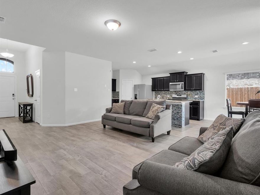 Beautifully kept one-story layout offers 4 bedrooms, 2 full baths, 2-car garage and an open floor plan that makes everyday living easy. The kitchen is the heart of the home with granite countertops, a large island with bar seating, gas range, and plenty of cabinet and pantry space. The living and dining areas flow together seamlessly, and the split bedroom design gives the primary suite added privacy. The spacious primary includes a walk-in closet and bathroom with dual sinks. Tile flooring runs throughout the main areas of the home, with carpet only in the bedrooms. Additional highlights include a separate laundry room and energy-efficient features. Outside enjoy a covered patio, full sprinkler system, and private backyard. Conveniently located near shopping, dining, major highways, and just minutes from Downtown Fort Worth.