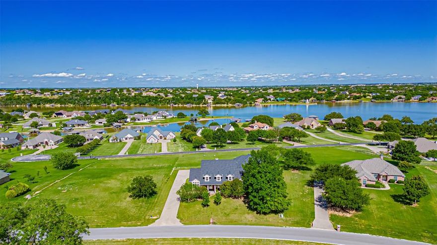 Come see this impressive custom home built by award winning builder Chris Thomas in the luxurious subdivision of The Peninsula on Lake Granbury.   Dramatic details throughout, elegant curved staircase, warm & inviting family room w gas log fireplace, formal & casual dining areas, beautiful wood floors, doors, ceilings & trim.  Kitchen is complete with huge walk-in pantry, solid surface counters, natural gas range, stainless steel appliances, RO water system. Outdoor living area has a large deck with retractable awnings, with a fabulous lake view!  Oversized concrete driveway provides ample parking. Over 1,800 sf of attached garage-workshop & RV garage plus 50amp elec, water & sewer hookup, remote door opener.  Workshop is fully insulated w half bath & window AC. New class 4 composition roof installed seven months ago.