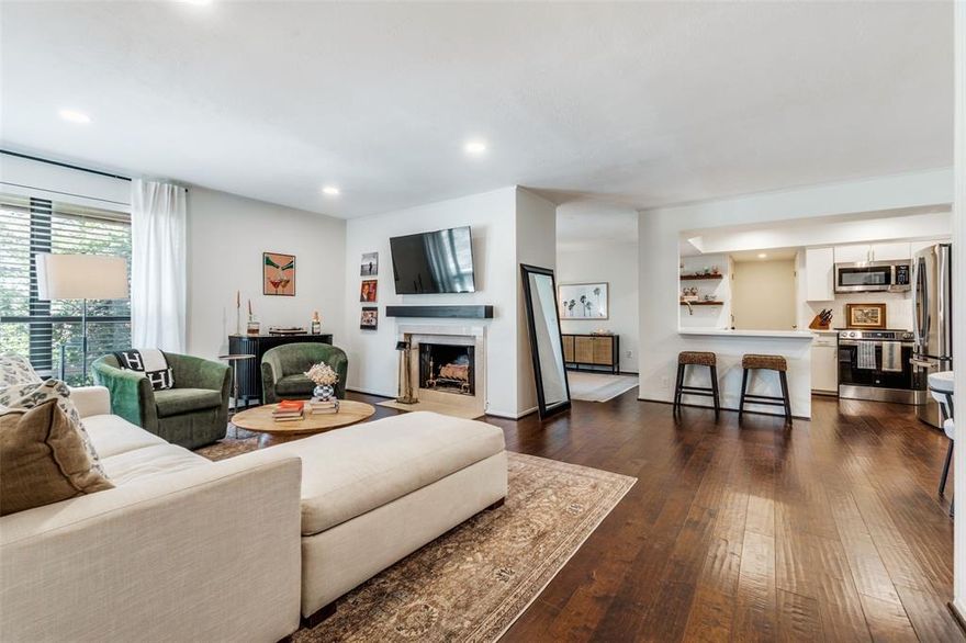 HOA includes ALL utilities and valet trash, an incredible value! This beautifully maintained and updated corner unit is filled with natural light and offers an open, airy layout that lives larger than its 1,234 square feet. Located in a charming, well-kept mid-century modern community with mature landscaping, a sparkling pool, and two dedicated covered parking spaces, this home combines style and convenience. Inside, enjoy treetop views through newer windows, an open-concept kitchen with quartz countertops, stainless steel appliances, and a walk-in pantry, plus a bright living area anchored by a wood-burning fireplace. A versatile bonus space is perfect for a home office or second living area. Storage is abundant with walk-in closets, built-ins, a dedicated laundry room with extra storage, and an outdoor closet. Generously sized bedrooms and two full baths complete the home. All just moments from Central Market, Greenville Avenue dining and shopping, SMU, and quick access to US-75. Move In Ready and excellent value at this price point!