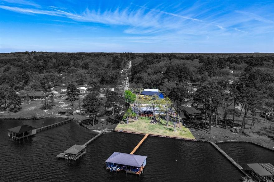 An extraordinary opportunity to own two complementary lakeview properties in Lakeway Harbor—23351 & 23374 Wateridge Loop—offering the ultimate blend of turnkey lake living, entertaining space, and investment potential on approximately .50+ acres. 23351 Wateridge Loop is a fully furnished renovated retreat designed for effortless indoor-outdoor living. Enjoy breathtaking sunsets from the 16’x30’ covered patio (2023), complete with seating, fire table, dining area, and mounted TV. A 15’ retractable sliding glass wall opens to a 10’ span, creating a seamless flow to the backyard and lake. Updates include new appliances, added dorm-style bedroom, and a third full bath with direct patio access. The outdoor space features bistro lighting, a large fire pit with seating for 8, lake-fed irrigation, and extensive drainage improvements. The boathouse is equally impressive with two electric lifts, storage with bar top, Spider Mister system, walk-down water access (2025), and a sought-after “sugar sand” lake bottom ideal for recreation. 23374 Wateridge Loop (built 2025) elevates the experience with a modern home and a 2,000 sq ft party barn built for entertaining. The home includes a whole-home generator, high-end finishes like soft-close cabinetry, crown molding, wood-look blinds, electric fireplace, and a new front deck (2026). Behind the home, the party barn features three electric garage doors for indoor-outdoor flow, four mini-split systems, a hidden speakeasy behind a secret bookshelf, and a large storage area. A 1,000 sq ft covered patio and additional grassed lot offer space for recreation, storage, or future expansion with its own septic system. Located in Lakeway Harbor, just 15 miles from Tyler, residents enjoy a private boat launch, park, playground, and upcoming community garden. Lake Palestine is renowned for fishing and hosts tournaments year-round. Together, these properties create a rare, all-in-one lakefront lifestyle or income-producing opportunity. SEE PR