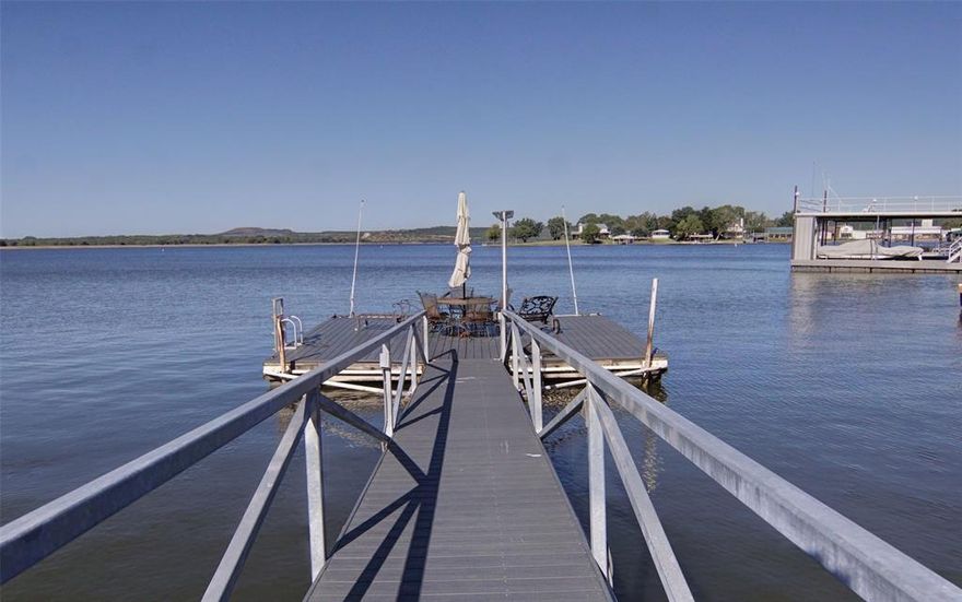 LISTING NOW INCLUDES 2500 SQUARE FOOT NEW BOAT BARN, on second lot that's 0.272 acres, conveniently across the street from your new lake home. Finished out and plumbed if you'd like to convert it into more living space, it's also climate controlled! Both are on a quiet road and the main house sits on the pristine shoreline of Possum Kingdom Lake. Main house is remodeled, comes furnished, turn key and ready for you to enjoy. Enjoy a setting with mature trees that provide shade and enhance the ambiance while taking in some of the absolute best sunsets you've ever witnessed. Flat, level lots with St. Augustine grass feels great on your feet as you dip your toes in the water, or drop a line for the big catch of the day! Swim dock and walkway really add to the lake front experience. This special, meticulously well maintained property is literally everything what you'd want in a lake home, and more! The entire upstairs is a huge, primary suite complete with sitting area which can double as an office with a view! The primary bath and huge walk in closet are what dreams are made of, truly spectacular! You'll enjoy the black out electric shades that keep your home cool in the summer and can't help but assist in the best night's sleep. Outdoor shower really comes in handy, every lake home should have one!  Located on the highly sought after Peninsula, you're very close to many options for dining, live entertainment and shopping. Possum Kingdom Lake, also known as the Great Lake of Texas is not only scenic, but offers all the fun boating, surfing, fishing and floating fun one would want. You'll be in awe of the 200 foot bluffs and topography, it's a magical place that will keep you coming back for more.