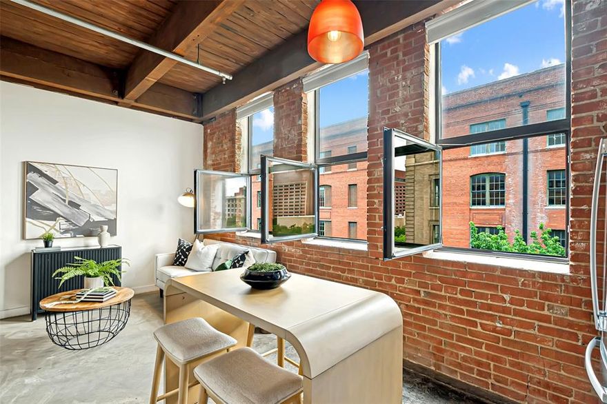 This Elm Place Residence offers an authentic loft aesthetic with exposed brick, cedar beams, concrete floors, and three working casement windows that fill the space with natural light. Historic character is complemented by meaningful updates, including a new HVAC system, refrigerator, washer, and dryer. The open layout lives comfortably with flexible living and dining spaces, plus a dedicated bedroom area with ceiling fan and a large walk-in closet. The modern, sleek kitchen features wood cabinetry, marble waterfall countertops, stainless steel appliances, and ample storage and prep space. The beautifully updated bathroom offers herringbone tile, an updated vanity, a large tub and shower combination, and built-in linen shelving. A side-by-side in-unit laundry area with additional storage adds everyday functionality. Building amenities include 24-hour security, secured garage access, a fitness center, and a landscaped courtyard. Outside, you are moments from Dealey Plaza, American Airlines Center, Downtown, the West End, Victory Park, Trinity Groves, restaurants, entertainment, and major downtown access. A DART station just a block away provides convenient access across Dallas and beyond. Reserved parking spaces beneath the building are available for lease at approximately $150 per month. A true lock-and-leave loft offering historic character, stylish updates, and a location that puts Downtown Dallas at your door.