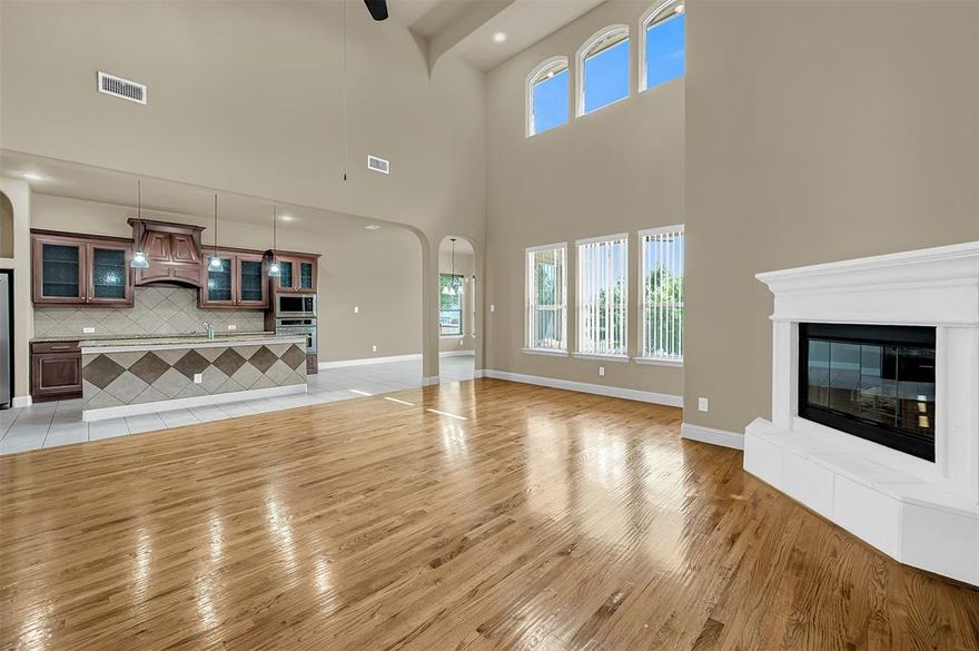 Welcome to luxury living in The Estates at Grand Peninsula, one of Grand Prairie’s most sought-after communities. This spacious 4-bedroom, 4-bath home at 2723 Portside Dr offers 4,220 sq ft of beautifully designed space on a quarter-acre lot, backing to a greenbelt with scenic water views. Inside, you'll find hardwood floors, granite countertops, soaring ceilings, and an open-concept layout filled with natural sunlight from an abundance of windows throughout the home. The gourmet kitchen features a large island, built-in cabinetry, two pantries (including a walk-in), a built-in coffee bar, plumbed for a gas range, and opens to a breakfast nook and expansive living area with a gas-log fireplace. Oversized rooms include a formal dining area, a main-level primary suite with a luxurious en-suite bath, and a secondary bedroom with full bath—ideal for guests or multigenerational living. Upstairs includes a massive loft, two additional bedrooms with private full baths, and a dedicated media room that’s wired, blocked, and features a Juliet balcony overlooking the front, along with a connecting wet bar—perfect for entertaining. Recent upgrades include a Class 3 roof (2023), two 50-gallon water heaters (2021), electrical updates (2022), and two HVAC units (2020), offering both comfort and energy efficiency. Enjoy outdoor living on the tiled, covered patio with a gas drop and stunning pond and greenbelt views. The backyard gate opens directly to a walking trail around the pond and nearby park. Additional features include a 3-car garage, tinted windows, iron and wood fencing, sprinkler system, gutters, and security system. Located in The Estates at Grand Peninsula, zoned to Mansfield ISD, and just minutes from Joe Pool Lake, shopping, and dining. Community amenities include a pool, a fitness center, clubhouse, parks, greenbelts, and trails.