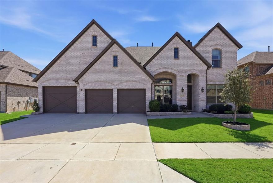 Get ready to fall in love! Built by Stonehollow Homes and zoned to highly sought after Prosper ISD, this beautifully designed 5 bedroom, 4.5 bathroom home offers space, style, and flexibility on an oversized lot. With 2 bedrooms downstairs, including the private primary suite, this layout is both functional and inviting.

The grand entry makes an immediate impression with a sweeping curved staircase, soaring ceilings, and beautiful hardwood floors. The open kitchen and living area is the heart of the home, featuring white cabinetry, a large island with seating, farmhouse sink with an upgraded faucet, stainless steel appliances, gas cooktop, walk-in pantry, and plenty of prep and storage space. The living room is anchored by a stunning stone fireplace and flows easily for everyday living or entertaining. Upgraded lighting throughout the home and motorized blinds downstairs add both convenience and a touch of luxury.

The downstairs office offers a quiet work-from-home space, while the spacious primary suite includes a spa-like bath with dual vanities, soaking tub, separate shower, and customized walk-in closet. Upstairs you will find 3 additional bedrooms, including two with an ensuite bath, plus a huge loft-style family room, a separate sitting area, and a media room.

Step outside to enjoy the covered back patio complete with a hot tub, fireplace, TV setup, and room to relax or entertain. The oversized backyard offers plenty of green space to enjoy, while JellyFish exterior lighting adds standout curb appeal in the front. Car lovers, hobbyists, or anyone needing extra storage will appreciate the rare 5-car garage.

This home checks all the boxes, blending luxury details with a warm, livable design in one of the area’s most desirable school districts.