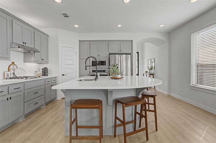 Looks and shows like a model. Everything in this beautiful home was upgraded when it was built or shortly after. Special features like an outlet in the custom pantry that includes a space for the trash can, motorized shades on the high windows in the living room, custom storage in the primary bath which also has an AC outlet. 20 foot ceilings in the living room. An inviting kitchen that opens to dining and living with a large island bar that is perfect for entertaining. There is even a split AC unit in the garage for the hot summer days if you want to use that for an exercise space. Private office adds to this great floorplan. The primary bathroom has a large separate shower, two sinks with upgraded fixtures and amazing storage. The back patio features custom shades on the west side and a turfed extension of the back patio.