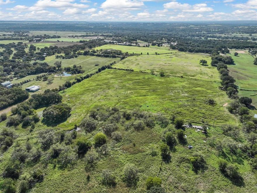 This 72 acre property is perfectly located 4 miles east of beautiful Glen Rose and 20 miles west of the Chisolm Trail.  It has 870 feet of Hwy 67, with 4 driveway entrances, and 1056 feet of County Road 303.  It boasts 30 acres in hay fields, a 15 acre Pecan Orchard, 2 stock tanks, fenced in pastures, Somervell county water, a private well, shed, and barn with enclosed shop!  The two story, 3056 square foot home is extremely spacious with an open floor plan. Comprised of 4 bedrooms, 3 baths, a 3 car garage, and RV parking with 2 primary bedrooms.  It has plenty of charm with a huge fireplace and spiral staircase but needs some TLC.  This property offers a multitude of possibilities whether you’re looking for a retreat from the city or a residential development.  Keep your preferred acreage and subdivide the rest off.  2 access points provide plenty of opportunity and the views are absolutely stunning! No city taxes or restrictions.  Welcome home to the beginning of the hill country!