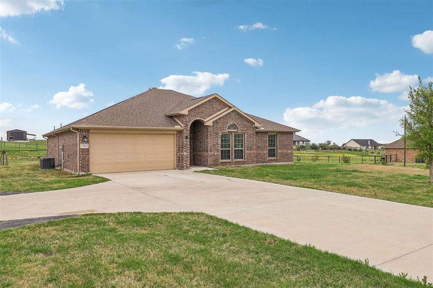 Nestled on a serene one-acre lot under the vast Texas sky, this stunning 3-bedroom, 2-bath home offers the perfect blend of comfort and charm. From the moment you enter, you're greeted by an abundance of natural light that fills the spacious living area, complete with a stately fireplace and custom built-in shelves. The open-concept design seamlessly connects the living room to the beautifully appointed kitchen, featuring an island with seating, built-in stainless steel appliances, ample storage, and a bright breakfast nook—ideal for morning coffee and casual dining. French doors lead to an elegant home office, perfect for remote work or a quiet retreat. The primary suite is a private oasis with a luxurious ensuite bath, dual sinks, and a generous walk-in closet. Two additional bedrooms provide ample space for family or guests, complemented by a well-appointed secondary bath. Enjoy  the expansive backyard, where a covered patio invites you to relax and entertain while enjoying the peaceful surroundings. Don't miss the shop with electric and water and the covered parking for an RV or additional cars. With its thoughtful design and inviting atmosphere, this home is a true Texas gem!