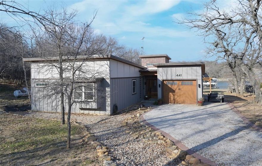 Welcome to your IMMACULATE CUSTOM BUILT LAKE HOUSE with tranquil, scenic water views of Lake Bridgeport, where craftsmanship, modern elegance, and Texas living all come together in perfect harmony for leisure and recreation! This stunning custom home sits on .43 acres and has been thoughtfully designed inside and out, including a separate 160 sq. ft. Guest House, Cabana, Fishing Doc, addtl' side parking, and 253 sq ft covered back porch with Lake views for miles! Owners pride shows throughout this amazing, spotless home! The Chef's Kitchen features granite countertops, counter to ceiling tiled backsplash, huge solid wood topped Island with double-tiered pendant lights, custom cabinetry, accent lights, black hardware, two revolving corner lazy Susan's, six pull out spice drawers, four wine racks and stainless steel appliances with five burner gas stove. LVP floors and custom wall treatments flow throughout the house, creating an excellent canvas for any décor. The spacious living offers a cozy Faux electric fireplace and flows into both the kitchen and dining, opening to the enclosed back porch. The primary suite is a peaceful retreat, with window seat, a luxurious en-suite bath with oversized shower, separate free standing tub, quartz topped two sink vanity with medicine cabinets, walk-in closet with stacked hanging racks and wall to wall built-in storage. Hall Guest bath plus a separate Office with barn door entry, wrap around wood topped built-in desk and an upper level loft with sleeping quarters and built-in wall storage, perfect for the Kiddos! Large laundry room with built-in cabinets, shelves and storage closet. Elegant front wood and glass sidelight entry door, front exterior up lights, extra deep garage with work bench and room for equipment, plus a pavestone rear sitting area and much more! This exceptional property offers a rare combination of privacy, views, and lifestyle in a uniquely peaceful setting. Schedule your showing today!