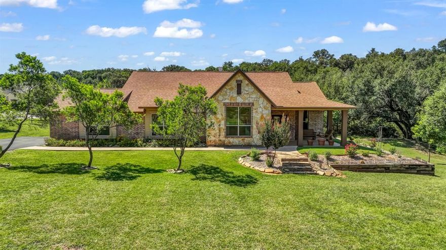 This immaculate 3 BDR 2 BATH one story home at The Hills above Possum Kingdom Lake is nestled on a tranquil two acre property at the end of a cul-de-sac. Plenty of privacy with the sights of wildlife all around including deer, turkey, roadrunners, and a myriad of birds. You will enjoy the sights of butterflies and birds enjoying the variety of flowering bushes and trees around the beautifully landscaped land.  This house has been impeccably maintained.  Open concept living, dining, and kitchen area with huge windows that line the back of the house for full enjoyment of the natural surroundings. The scratch proof and waterproof  laminate throughout the house is dog and kid friendly.  Some of the other unique features of this house inlcude:  900 linear feet of invisible fence to keep animals in and others out, 200 feet of an attractive stone swail that allows for water control and drains into a creek in the back of the property, extra large kitchen island, kitchen appliances updated to KitchenAide approx one year ago,   microwave is a convection oven & microwave combo which can serve as a second oven in the kitchen, and hand scraped hardwood floors in secondary bedrooms. You will also enjoy the upscale amenities that come with living at The Hills including the gorgeous community infinity swimming pool and clubhouse, community lake cabin and boat dock, and community pond and boat storage.  This is a great time to come out and look at this beautiful property as temperatures are finally cooling down!