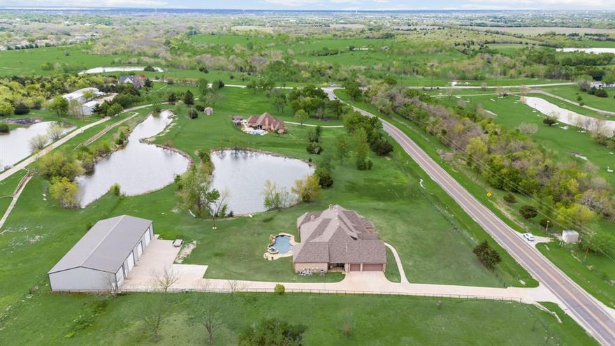 This unique 1 story property is nestled on 4.7 acres of pristine land with stocked ponds offers country living with the perfect blend of luxury and functionality.  This pristine property has a 4550 SF+ Commercial grade workshop with 20 ft. center, electric, water, and (1)12ft and (3)14ft. bays plus a seperate RV garage with hook-ups.  The extra concrete parking ensures ample space for additional vehicles, trailers and guests.  This spacious home offers a well designed floor plan  featuring multiple living areas including a large family room with stained truss beams and a stone fireplace adjoining the fabulous custom cooks kitchen with large prep island, stainless appliances and lots of cabinet storage including a Butlers pantry.  The huge gameroom and dedicated theatre room are ideal for entertaining and family gatherings.  The large master suite offers a sitting area and luxury bath with views of the pond and a custom 10 x 11 safe and shelter with combination door.  Enjoy the peaceful serenity of the private fishing pond or relax poolside with spa and waterfalls and enjoy the beautiful evening sunsets.  The well equipped workshop construction includes a 6inch concrete slab with piers, ideal for a home business, the hobbyists or a craftsman.