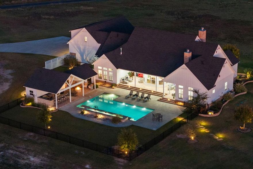 Experience resort-level comfort and refined rural living on 46 picturesque acres in Waxahachie, Texas—an exceptional luxury ranch estate just one hour from DFW International Airport and Dallas Love Field. Designed for privacy, presence, and multi-generational living, this gated property features generous road frontage, multiple entrances, a creek winding through the land, and a dedicated rear water meter ideal for a future family compound.

The 4,110-square-foot custom luxury farmhouse blends elevated design with authentic Texas functionality. Offering four bedrooms, four full and two half baths, the home includes two private primary suites with fireplaces and heated bathroom floors. Vaulted ceilings, shiplap accents, three-foot doorways, electric blinds, custom shutters, spray-foam insulation, dual tankless water heaters, and a whole-home generator reflect thoughtful craftsmanship throughout.

The chef’s kitchen is appointed with Sub-Zero and Wolf appliances, an oversized island, a spacious walk-in pantry, secondary refrigerator, and dedicated ice maker. A private office with exterior entrance supports executive work-from-home living, while the loft retreat with custom bunk alcoves creates flexible guest space.

Outdoor living rivals a private resort, featuring a pool with chiller and jetted lounge, pool house with bath, and fully equipped covered outdoor kitchen. A climate-controlled motorcoach garage with septic hookups and laundry, plus extensive barn and storage facilities, make this property ideal for entrepreneurs, ranch enthusiasts, or those seeking a luxury DFW ranch with expansion potential.

Neighboring 95 acres also available. Combine for 141 contiguous acres, with an additional 624 acres across Higgins Road extending to FM 876.
