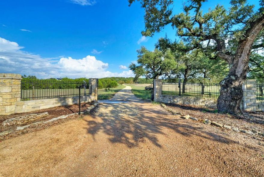 Welcome to Sawyer Summit, a 32-acre gated estate on Sawyer Ranch Rd. Exceptional security & privacy, inc. elevated hilltop location, propane generator, 3 water sources, & fortified AC storage room. Can be divided 3 times. Groomed land, rolling terrain, & stunning views. Flexibility & minimal restrictions, no HOA, allowing subdivision into 7.5-acre parcels. Wildlife exemptions for low taxes, & access to esteemed Dripping Springs ISD. 5K sqft custom home with pecan wood flooring offers 4 bedrooms, each with private bath. Heated-cooled 3-car garage & a Class 4 metal roof add comfort & security. 2 agricultural wells & connected to public water. A generator ensures uninterrupted power. Propane tanks serve home. Homesites with panoramic Hill Country views. Equestrian haven features a 2021 horse barn with 2 stalls, pasture access, & convenient amenities. NRA-designed gun range also available. 3,520 sqft metal barn inc. a 22kW Generac generator, underground propane tanks, well storage tanks.