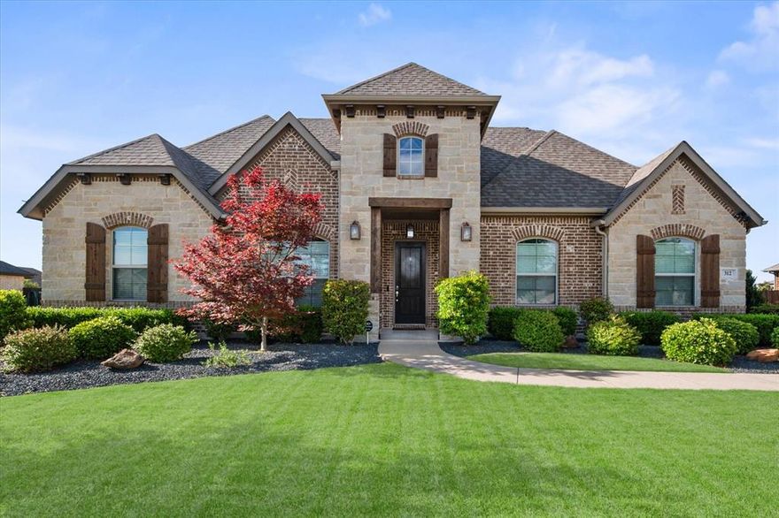 Welcome to this beautifully maintained 4-bedroom, 2.1-bath home located in the desirable Sandstone Ranch subdivision in Waxahachie, TX. Designed with comfort and style in mind, this move-in ready home features an open floor plan perfect for both everyday living and entertaining. Step inside to find rich wood and ceramic tile flooring flowing seamlessly throughout the living room and kitchen. The inviting living area is anchored by a stunning stone fireplace, creating a warm and welcoming focal point. The kitchen is a true highlight, boasting a spacious island, sleek granite countertops, and modern decorative accents that add both elegance and functionality. The primary suite offers a private retreat with an ensuite bath complete with a relaxing garden tub, separate shower, and a generous walk-in closet. Upstairs, you'll find a versatile bonus space that can serve as a second family room or game room, complete with its own half bath. Enjoy outdoor living at its finest as you step from the breakfast nook onto a covered back patio overlooking a large, grassy backyard. The beautifully landscaped yard provides the perfect setting for relaxing or entertaining. In addition, the home features two garages with three total spaces, including a one-car garage with tall ceilings and extra length—ideal for accommodating a large truck or transforming into a workshop or home gym. This home truly has it all—style, space, and comfort—ready for you to move in and make it your own.