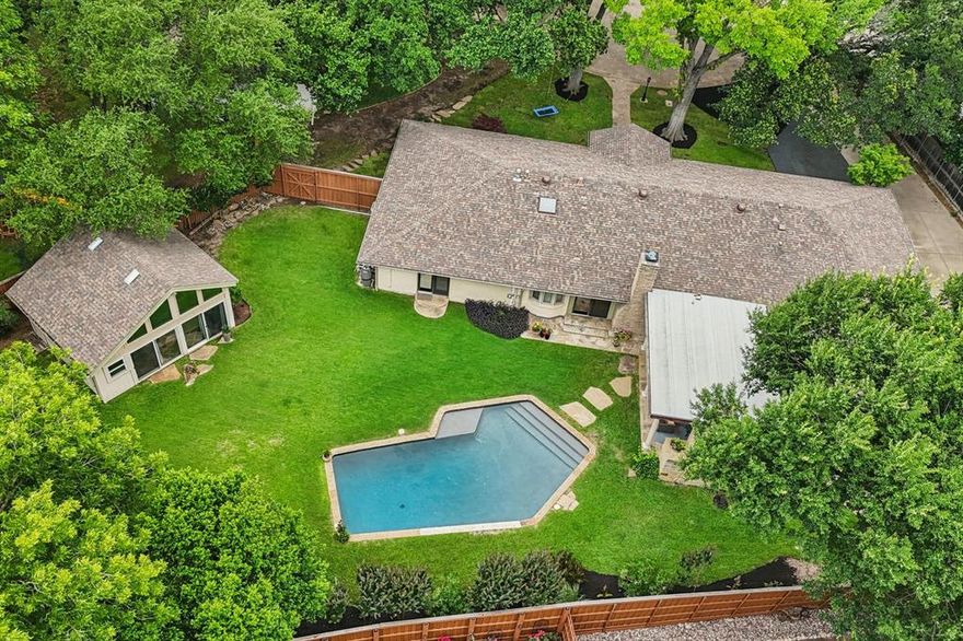 Discover timeless elegance and everyday comfort in this beautifully updated single-story ranch home, ideally situated on nearly half an acre in a quiet cul-de-sac in the heart of Preston Hollow's Windsor Park neighborhood. The open-concept layout features a spacious island kitchen and breakfast nook that flow seamlessly into a vaulted living room with wood beam accents and a gas log fireplace. A private office and formal dining room offer flexible spaces for work or entertaining, while a thoughtful split floor plan provides exceptional privacy. The expansive primary suite includes dual walk-in closets and additional wardrobe storage, with two guest bedrooms nearby. A separate guest suite and a private game room—easily used as a fifth bedroom—adds versatility. Practical highlights include an oversized mudroom, abundant storage, and a oversized two-car garage. The lush backyard retreat is perfect for relaxing or entertaining, with a sparkling pool, covered patio with fireplace, and a full guest house complete with kitchen, bathroom, and Murphy bed.