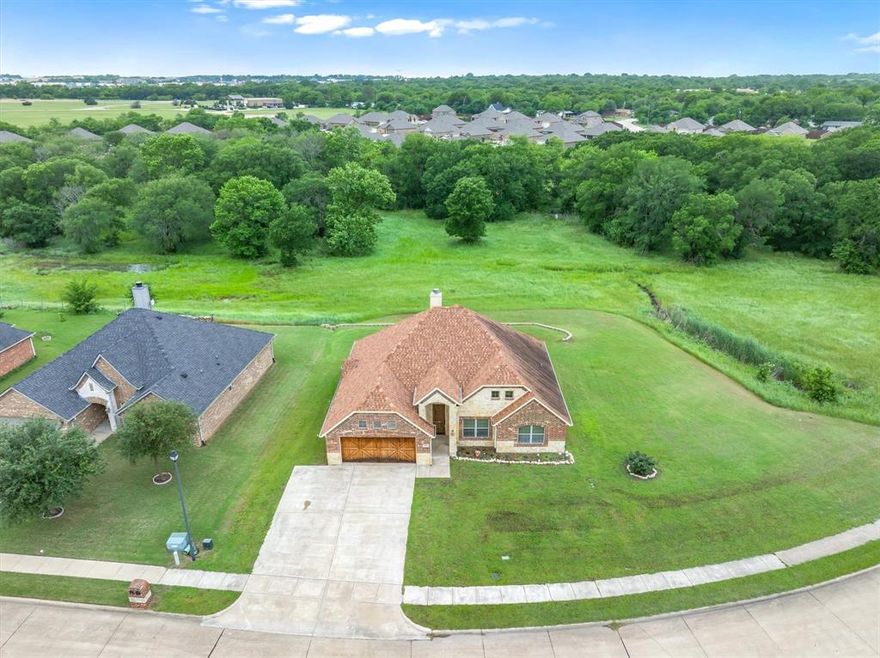 ESTATE SALE THIS WEEKEND + FRIDAY 9–5 & SATURDAY 9–4
Explore at your own pace and take home a piece of history—Grandma’s beautiful china and treasures, but make no mistake…the real prize is the property itself. Positioned on one of the most desirable lots in the neighborhood, this corner lot backs to the Prairie Creek green space, offering privacy with only one neighboring home and unobstructed views of nature.
The curb appeal is unforgettable showcasing a striking roofline, grand entry, and upgraded cedar garage door set the tone. Rustic cedar accents, gables, and porch posts create a warm, inviting exterior that complements the surroundings.
Out back, enjoy a private retreat designed for entertaining, complete with a spacious covered patio and stone retaining wall—perfect for hosting or unwinding while taking in the views and wildlife.
Inside, the home continues to impress. A welcoming foyer opens to a stunning Austin stone fireplace with a cedar mantel and tall hearth. The open-concept floorplan features soaring cathedral ceilings and arched doorways, creating a light, airy feel throughout. The split floorplan offers both comfort and privacy.
The kitchen is a showstopper with custom all-wood cabinetry, an Austin stone island with built-in electrical, stainless farmhouse sink, decorative lighting, and abundant storage. Complete with a stacked stainless oven and microwave, glass cooktop, and extensive cabinetry—built to impress and function.
The primary suite is a retreat of its own, highlighted by a hexagon ceiling and natural light. The ensuite bath offers dual vanities, a glass-enclosed shower with seating and waterfall showerhead, plus a separate soaking tub.
Generous storage and large closets in every bedroom. Easy commute to Dallas in under an hour while enjoying the charm and tranquility of small-town living.
Tour this weekend and experience it in person—homes like this don’t last. Professional photos coming soon.