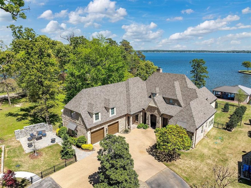 Exceptionally beautiful waterfront home with amazing open-water views on Lake Palestine! Custom built by Ed Kopal on  .623 acrs, this 4 bedroom, 4 bath home has open living, dining & kitchen, beamed ceilings, picture windows, stone WBFP, with custom built-ins. Gourmet kitchen(See features)!  Travertine tile floors downstairs, with wood-look tile in bedrooms. Two bedrooms & two baths downstairs, office with built-ins, utility room with sink & space for extra refrig., + bonus room for pets, etc... Upstairs: bedroom with bath, + huge bonus room & bath-used as a bedroom! Great storage throughout, plus floored attic! Covered patio! Sidewalk to Fire pit & 3 stall boathouse, with electric lifts + storage & refreshment area! Misting system! Briggs & Stratton generator (2022). Neighborhood amenities: elegantly designed common areas, security gate, picnic pavilion with fireplace, waterfront fire pit, day marina, a boat ramp, separate gated & fenced storage area for your trailers, boats, & RV's!