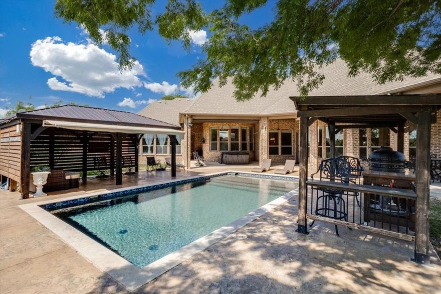 Stunning custom-built home in DC Ranch, one of Celina’s most sought-after communities, known for its one-acre homesites, peaceful setting, and strong neighborhood feel, all just minutes from Celina High School and Bobcat Stadium. Situated on a beautifully landscaped 1+ acre lot, this meticulously maintained 4-bedroom, 3.5-bath home offers exceptional quality, thoughtful upgrades, and seamless indoor-outdoor living. The open-concept floor plan showcases spacious living and dining areas, tall ceilings, 8-foot doors, crown molding, and custom finishes throughout. The chef’s kitchen is equipped with granite countertops, a Bosch induction cooktop (2023), dishwasher (2023), and garbage disposal (2026), all flowing effortlessly into the main living space. Recent mechanical upgrades include 2 HVAC systems replaced within the past 3 years, professionally cleaned air ducts, new ductwork in the rear of the home, and UV antibacterial air purification systems for enhanced air quality. The efficient septic system supports irrigation reuse. The primary suite has been beautifully updated with new tile flooring, a fully remodeled custom closet (2025), and updated lighting. Additional highlights include built-in living room cabinetry, a spacious laundry room with granite counters, utility sink, and room for freezer, plus abundant storage throughout. Designed for year-round enjoyment, the backyard features a heated pool with cabanas, a large covered patio with fireplace, automatic awnings, and a custom privacy screen for enhanced comfort. Three Big Fans provide added airflow on the patio and in the garage. The fully fenced property includes mature trees, new sod, additional fenced garden or pet area, and a 3-car garage with access to a massive walk-in attic. This home combines comfort, efficiency, and elegant design in a prime Celina location.