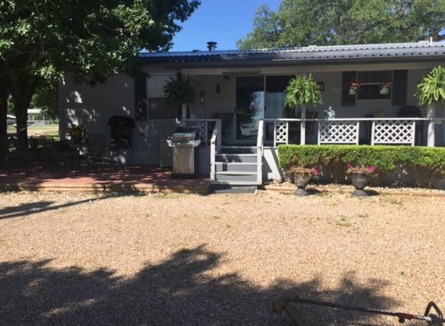 Welcome to this beautifully situated 3-bedroom, 2-bath lake property designed for comfort, relaxation, and unforgettable family moments. The home features a spacious living room and a well-appointed kitchen with dining area, breakfast bar, and built-in cabinetry—perfect for everyday living and entertaining.Step outside to a covered porch spanning the entire back of the home, where you can take in stunning views of Lake Whitney. A cozy, tree-shaded patio offers a secluded outdoor retreat, ideal for morning coffee or evening gatherings while enjoying the peaceful lake scenery.
This secluded property provides walking access to a scenic cove, inviting you to dive in and enjoy boating, kayaking, and fishing just minutes away. Whether hosting family weekends or creating lasting memories by the water, this home offers the ultimate lake lifestyle.
Additional features include a beautiful workshop, two-car garage, and the home is sold fully furnished, making it truly move-in ready. Bring the family, embrace the outdoors, and start enjoying lake life today.