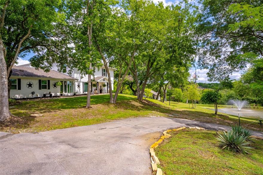 Motivated Seller!!  Experience serene country living on this remarkable 2.3-acre property, where privacy, thoughtful design, and natural beauty come together seamlessly. The main residence welcomes you with a spacious open-concept layout, ideal for hosting gatherings or enjoying everyday living with ease. The home offers 5 bedrooms, 4.5 bathrooms, and a versatile game room that can effortlessly serve as an additional bedroom if desired.  Outdoors, the expansive grounds invite both relaxation and recreation, with room for two horses and space to enjoy the open landscape. A picturesque pond, complete with a floating aerator fountain and stocked with catfish, perch, and crappie, enhances the setting. The backyard is a true retreat, featuring a sparkling pool, a calming fountain, and a dedicated dog run for pets. An inviting guest quarters, currently styled as a sports-themed entertainment space, adds flexibility for work, leisure, or hosting. The front and back yards are supported by a sprinkler system fed by well water, while the home itself is on city water with the option to easily convert to well water if preferred, offering both efficiency and versatility. Located just five minutes from Lake Weatherford Marina, with access to a boat ramp, dining, volleyball leagues, and shopping at the Shops of Willow Park, and only a mile from Squaw Creek Golf Course, this property delivers an exceptional balance of comfort, convenience, and the peaceful rhythm of country living.