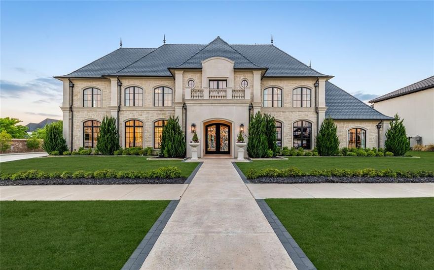 Set within the prestigious guard-gated Homestead enclave of Newman Village—one of Frisco’s most exclusive neighborhoods—this sculptured stone masterpiece sits on a prime corner lot with abundant natural light and sunlight. The modern French chateau, blends timeless architecture with elevated finishes for grand elegance and effortless living.

The striking stone exterior welcomes you through wrought-iron doors into a luminous two-story foyer with sculptural staircase, oak floors, and exquisite millwork. The sun-splashed great room features twin brass ring chandeliers, Turkish quarry fireplaces, and a dramatic wall of glass framing courtyard views.

The stunning kitchen impresses with a Sub-Zero fridge, Wolf dual oven, large island, and pantry. A temperature-controlled, walk-in, wine room sits right off the kitchen and dining area. Off the entry is a dream home office with navy tones, floor-to-ceiling built-ins, and a wet bar. Upstairs, a refined lounge with full wet bar anchors a plush media room and cinematic theater.

The serene primary suite downstairs includes his-and-hers closets and outdoor access, highlighted by a boutique-style dressing room with glass displays, shoe galleries, extensive drawers, and a marble island under a sparkling chandelier. Stone pavers lead to a pristine pool and raised glass-tile spa, flanked by covered loggias with outdoor fireplace and TV—perfect for year-round entertaining. Multiple sunning zones and seamless indoor-outdoor flow create a private resort feel, enhanced by a heated outdoor eating area and full outdoor kitchen.

A tornado shelter, whole-home Control4 automation, water filtration system, Generac generator, epoxy garage floors, landscape lighting, and security cameras add convenience and security. Located in Frisco ISD (Newman Elementary), this immaculate 8,150 sq ft estate offers the ultimate in luxury and resort-style living.