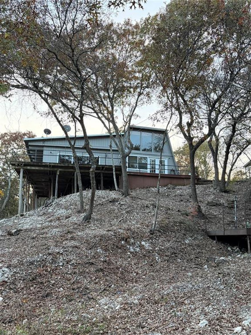 Adorable, quaint cabin priced right and ready for your personal touch! Relax on the large deck with a peek of the water, the abundant wildlife, from deer grazing in the yard to beautiful birds soaring overhead. Air conditioning was replaced in 2010. Minutes from the public boat ramp. Whether you're seeking a weekend getaway, a peaceful retreat, or a cozy year-round residence, this lakeside cabin is for you!