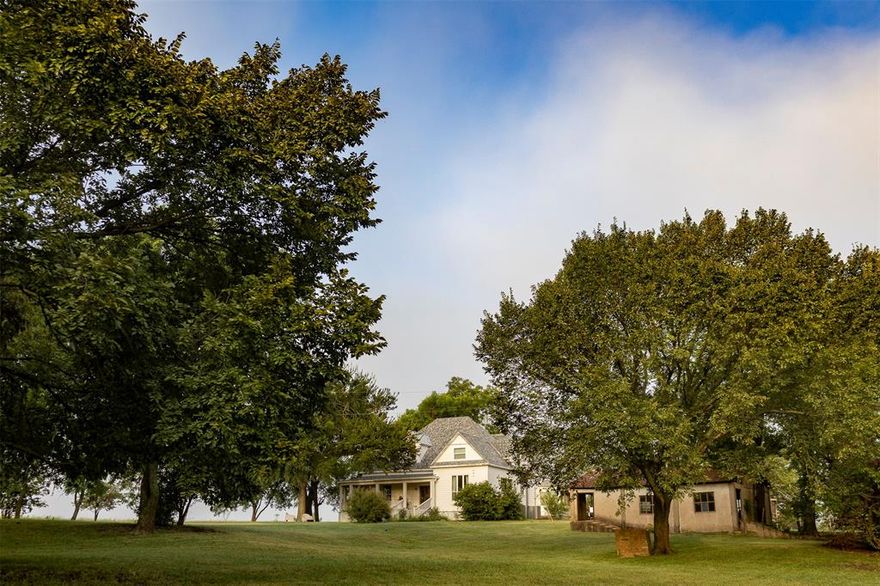 Own an authentic piece of history with this beautifully preserved 125 year old farmhouse on 8 acres in Grayson County. Built in 1900, this rare find comes with modern updates to plumbing, electrical and more without stripping away the charm of 11-foot ceilings, original wood, and farmhouse authenticity. The welcoming wraparound porch creates the perfect spot for morning coffee or evening relaxation. There is ample green space for gardening and keeping animals, two original barns provide storage and possibility, including a heated & cooled workroom. A charming picket fence surrounds a garden area surrounded by a mature park-like setting with access to a shared fishing pond. RV owners will appreciate the full hookup. Located just 4 miles from Texas Instruments, a short drive to McKinney, a few minutes to Sherman, and within easy reach of DFW, experience the joy of country living with immediate access to modern convenience. Whether you're searching for a weekend escape or a forever home, this farmette provides authentic farmhouse living with a soul and patina that simply cannot be recreated today.