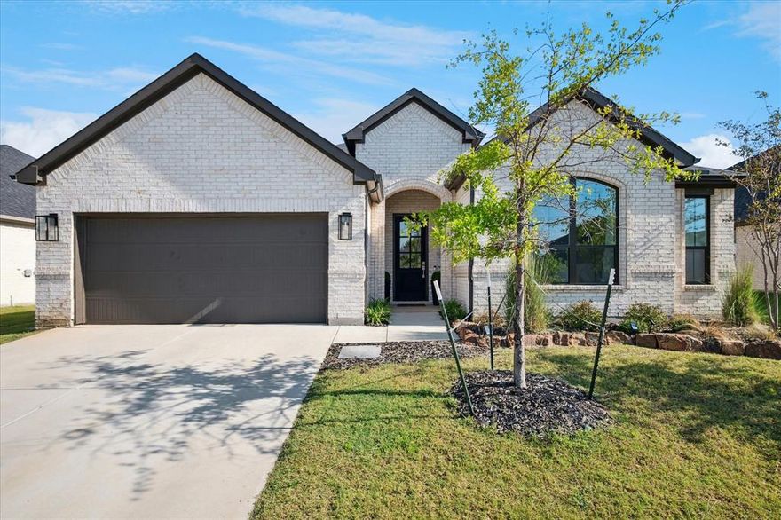 Elegance and charm define this beautiful home near UNT’s Discovery Park. Step inside to find stunning engineered wood flooring flowing through the open-concept main living area, filled with natural light. The modern kitchen features a large center island ideal for entertaining, quartz countertops, stainless steel appliances, a walk-in pantry, and a stylish backsplash. The spacious family room impresses with modern wood beams, floating cabinets, a cozy fireplace, and a wall of windows. A versatile second living area offers space for an office, craft room, or playroom, with abundant cabinetry for organization. The serene master suite includes space for a sitting area or desk, and the luxurious ensuite bath boasts a freestanding tub, separate shower, dual sinks, a linen closet, and a large walk-in closet. Secondary bedrooms are split for privacy and include walk-in closets and modern ceiling fans. The laundry room is thoughtfully designed to accommodate a freezer or an additional sink. Enjoy outdoor living in the oversized, private backyard featuring a covered patio—perfect for creating your dream retreat. Conveniently located near shopping, dining, and entertainment. Don’t miss your chance to see this exceptional home today!