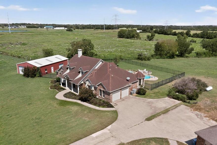 Hidden gem in Forney-Heath! Bring your vision of paradise to this almost 9-acre property with a large family home with salt-water diving pool and spa, shared half acre pond, huge 35'x60' workshop & barn ready for horses situated at the end of Saddle Club surrounded by estate custom homes. Have a slice of the country serenity combined with city convenience with easy access to Hwy 80 and I-30. Great Rockwall schools district & plenty of commerce & shopping conveniences near Rockwall-Heath. Property is not part of properties annexed by city of Heath, no HOA and lower taxes. Main house recently updated with hand scraped hardwood floors, interior painting, stone fireplace, island kitchen remodeled with new granite countertops, cabinets & stack stone backsplash; gas cooktop, stainless steel appliances & breakfast nook overlooking expansive covered patio & pool deck. Large game room off kitchen with built-ins & full-size bar. Full guest bath with easy access to pool, guest bedroom with ensuite bath down the hall from study. Master suite boosts remodeled master bath with new paint, oversize frameless glass shower and jetted tub. Near full 500-gallon propane tank for heating and fireplace and stove; recently replaced picture frame windows, pool was built in 2006 and had new pool pump and rebuilt heater in 2023. Updated AC units in 2017 and 2022. Bamboo wood flooring was added upstairs 2021. Massive 35'x60' building houses 20'x30' workshop with electric, window AC unit, 2 overhead rolling doors and 2-stall barn for horses.