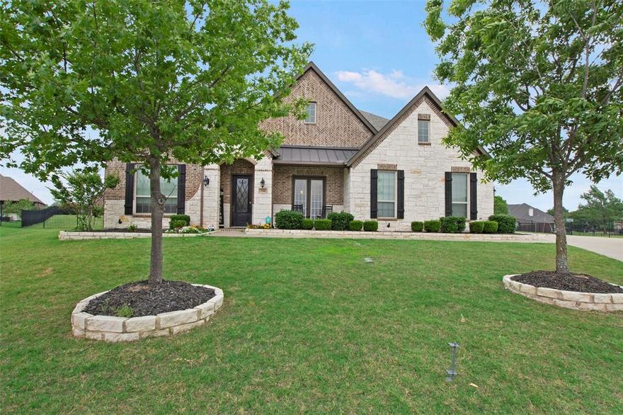 Luxurious one-story home located on a quiet cul-de-sac in a unique Heath, TX subdivision. From the striking entryway, you’re welcomed into a private office with built-in cabinetry and a formal dining room featuring wood ceiling beams—just the beginning of the custom craftsmanship seen throughout. Solid 8’ doors and 7” baseboards run seamlessly through the home, enhancing its elegance. The gourmet kitchen offers a walk-in pantry, soaring custom cabinetry, a butler’s pantry, and high-end appliances. The adjacent family room boasts a stone fireplace and wood beam ceiling, creating a warm, inviting space. The media room includes a large screen, projector, media equipment, and furniture—all of which stay with the home. The private primary suite is tucked at the back of the house with dual vanities, a soaking tub, separate shower, and a spacious walk-in closet. Two secondary bedrooms share a well-appointed Jack and Jill bath, while a fourth bedroom features its own en-suite bathroom. Step outside to your backyard retreat—featuring a large patio covered by a pergola, a stone fireplace, and a custom-built pool with hot tub and waterfall. Endless possibilities await! A separate document outlining builder upgrades and custom features is available for your review.