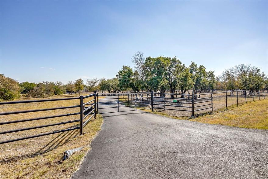 Surrounded by upscale properties & hidden behind 3 drive gates in the heart of Aledo, this AG exempt 8.8 acre ranchette offers one of Aledo’s most architecturally inspiring homes + barn in a magazine worthy setting. The drive curves around a modern barn to reveal the main home (3429 sqft) + detached structure (994 sqft) constructed with metal, cinderblocks and siding. Concrete planters, yucca, agave, a tall bald cypress...all create a Tx hill country vibe. Behind the glass front door lies a sensory integration of natural light, unique architectural lines & beautiful design selections. The home was last renovated in 2021. The spacious back porch & outdoor kitchen overlook a kidney-shaped pool evoking mid-century nostalgia (added in 2013). In 2021 an addition to the home enlarged the kitchen, added a large additional laundry & pantry space + enhanced the primary suite.  The expanded kitchen’s attention to detail and tasteful beauty are unparalleled: thick marble, butcher block, waterfall island with European panel detail, dramatic black 6 burner gas range with gold detailing, metal inset cabinet doors, aged hewn wood, soapstone, acrylic, glazed artisan tiles...countless phenomenal touches. The beautiful owner’s suite with backyard views with a spa-like bathroom & large walk in closet has access to laundry. The family room with plaster surround fireplace & hewn wood mantle has a tall, spacious ceiling (the room has over 35+ panes of glass), multiple sliding doors to the porch + a music or office space tucked on the side. From lighting and wallpapers to hardware and paint…the blend of colors and materials is pure delight. The detached structure offers a recreation room, upstairs guest suite, smaller garage bay for a shop or ATV.  The barn doors open to a large stall (could be divided into multiple stalls), wash bay, insulated tack & feed rooms, automatic water, with heat…  Round pin with seating & lights.  Property offers multiple pastures and extensive pipe fencing!!!