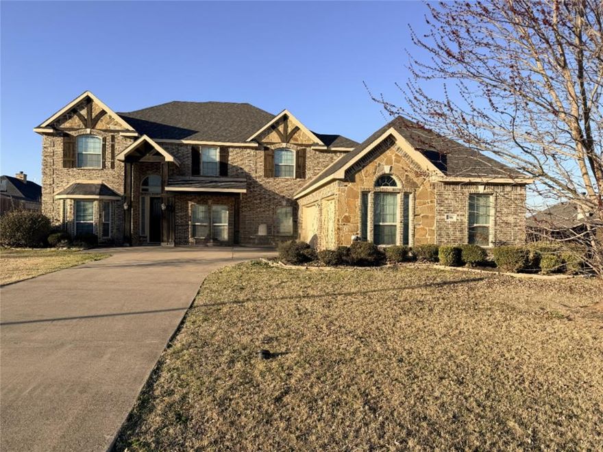 Step into luxury with this sprawling 6-bedroom, 4-bathroom masterpiece, boasting 4,486 sq. ft. of meticulously designed living space. The grand entryway makes a lasting first impression with soaring ceilings and a magnificent curved wrought-iron staircase. In the heart of the home, the great room features a dramatic floor-to-ceiling stone fireplace and rich espresso colored floors.

The chef’s kitchen is a showstopper, featuring dark cabinetry, granite countertops, a pot filler, butler’s pantry, and a massive center island. Retreat to the primary suite, where the spa-like bath offers a jetted tub framed by an elegant arched window and a modern glass-enclosed shower. Situated on a generous 0.34-acre lot, the exterior features a covered back porch perfect for entertaining and a full wood privacy fence enclosing the backyard. This home offers a rare combination of massive scale and intimate detail.