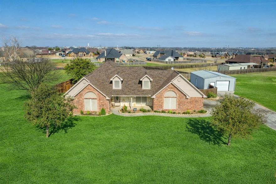 This stately 3 bedroom, 2-and-a-half-bathroom home sits on 1.35 acres in the Reatta Estates neighborhood of Decatur. No HOA! The large front porch is the perfect place to enjoy the quiet country setting. Inside, the split-bedroom floor plan includes a spacious primary suite tucked at the back of the house, 2 additional bedrooms with a Jack-and-Jill bathroom, plus an office. Enter through the decorative front door and through the entryway which has a half bath and spacious coat closet. A huge window lets tons of natural light into the living space, which boasts wide crown molding, vaulted ceilings with recessed lighting and has been updated with beautiful hardwood floors. French doors lead from the living room to the office which has a granite-topped built-in desk surrounded by built in wood cabinetry. The open concept floorplan means the living space gracefully leads into the dining area and cook’s dream kitchen with a breakfast bar, granite countertops, an island for additional prep space, tons of cabinet storage, and a separate pantry. The utility room includes additional storage, sink, and drip-dry area. Two guest bedrooms boast plenty of closet space, built-in shelving, and share a Jack-and-Jill bathroom. Tucked at the back of the house is the primary suite.  The spacious bedroom has an ensuite bathroom with deep, jetted bathtub and separate shower. Double doors open into a huge walk-in closet. The driveway leads to the oversized side-facing two-car garage and extends to a 24’x36’ metal shop with electricity. The huge back yard is surrounded by a wooden privacy fence and has a covered porch with an extended concrete patio perfect for a backyard barbeque with friends and family or a quiet evening enjoying the outdoors. This is a beautiful home has everything you need to be the perfect place to start your next adventure!