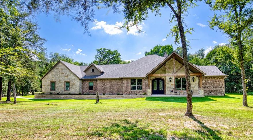 Welcome to your private oasis in the highly sought after Shadow Lakes neighborhood of Wills Point, TX. This immaculate custom built, single story home rests on 10.84 acres of serene, wooded landscape, offering the ideal balance of refined luxury and peaceful country living. The expansive acreage invites you to hike, explore, garden, or simply soak in the stillness of nature. Inside, you’ll find an open concept layout featuring 4 spacious bedrooms, 3.5 elegantly designed bathrooms, a dedicated media room for movie nights, and a versatile home office perfect for remote work or quiet study. The bright and airy living area showcases a vaulted ceiling with exposed beams, a dramatic floor-to-ceiling stone fireplace, and seamless flow into the gourmet kitchen—complete with an oversized island, built-in stainless appliances, custom cabinetry, and a walk-in pantry that will leave guests amazed. Unwind in the spa-inspired primary bath, featuring a freestanding soaking tub and an expansive walk-through shower. Whether you’re hosting guests or enjoying quiet moments, the large covered patio offers the perfect setting—ideal for morning coffee or evening fires. Additional highlights include a 3 car garage with spray foam insulation, elegant double iron entry doors, spacious laundry and mudroom, tranquil private setting with mature trees and wide open space, and a scenic pond. This exceptional property offers the best of country living with convenient access to nearby amenities. Don’t miss your opportunity to own a slice of paradise in Shadow Lakes; schedule your showing today!