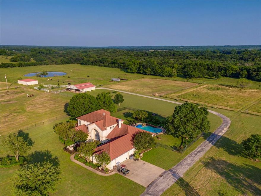 Welcome HOME to Longhorn Creek Ranch, very centrally located between Dallas and Fort Worth! This one owner stunning home with sparkling heated pool is nestled on a 135-acre spread - country living just got a whole lot bigger and better. Recently updated kitchen and master bath, two fireplaces, three living areas making the layout ideal for multi-generational living. Sit out by your pool and watch all the beautiful wildlife and soak up nature. The property features two ponds, fencing and cross fencing, custom low water bridge to the back acreage, two barns - one has three stalls with runs and the other is dirt floor with electric, ideal for cattle needs, and so much more! Just minutes from the quaint and charming downtown area of Maypearl. For the horse lovers the horse barn features wash rack, cooled tack room and full bath with room to expand stalls or build living quarters. NO CITY TAXES and has Ag Exemption in place. Property is a rare find - come see it today!