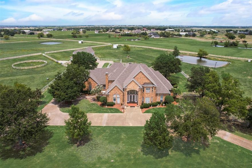 7-Acre Horse property in Bluebonnet Ridge Estates. This 5 bedroom, 5 bath custom home with 3 Car garage is ideally situated just 45 minutes from Downtown Dallas, nestled within the coveted Gated community of Bluebonnet Ridge Estates. This home features an expansive layout that includes two living areas, two dining areas, large game room, and a cabana bath with access to the pool. Enjoy seamless indoor-outdoor living with multiple patios and a gorgeous outdoor space featuring a built-in bar over looking pool with new tile and plaster. The gourmet kitchen boasts granite counters, a built-in refrigerator, double ovens, and a separate sink and cooktop on the island. Primary bedroom offers direct patio access, an en-suite bathroom with a jetted tub, separate shower, double vanities, and a spacious closet suite. Second bedroom downstairs currently serve as an office with a private side entrance, while three additional bedrooms and two full bathrooms await upstairs, including a convenient Jack and Jill bath. Step outside to your private oasis, complete with a diving pool, covered grilling area and plenty of outdoor living spaces.  PROPERTY FEATURES include a 4-Stall Barn with tack room and large shop. Above the Barn is a 1 bedroom 1 bath guest quarters with full kitchen. Attached is a large BUS BARN to fit your RV or trailers. Grounds include a round pin, washing station, mare sheds fishing pond with gazebo, and two on site water wells. Other LIVE stock allowed. Perfect property for  relaxation. This gated estate offers a rare combination of luxury, functionality, and security. Additional Highlights: More than the required number of foundation piers for added stability, constructed with durable 2x6 framing. contact us today for a showing. Some Photos Have virtual(AI) furniture. Motivated Seller !!