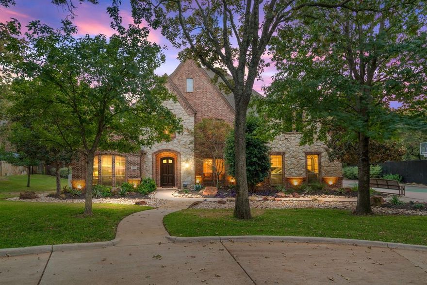 Experience refined luxury in this exceptional 5-bedroom, 5.5-bath estate, beautifully remodeled between 2021–2022 and set on more than 1.3 acres of lush, park-like grounds in the heart of Southlake. Surrounded by majestic, mature oak trees and just minutes from Carroll ISD schools, Southlake Town Square, and DFW Airport, this property offers the rare combination of privacy, space, and unbeatable convenience. A grand foyer welcomes you with a dramatic spiral staircase & striking designer lighting. The formal living room is flooded with natural light from two-story windows, framing tranquil views of the backyard & the stunning 32,000-gallon Claffey custom diving pool. At the heart of the home, the chef’s kitchen is both elegant and functional, featuring a large center island, natural stone countertops, gas range, double ovens, and abundant cabinetry. The kitchen flows effortlessly into the breakfast area & a beautifully updated family room—each framed with oversized windows maximizing the views. The primary suite is a true sanctuary, offering a spacious sitting area & a recently remodeled, spa-inspired ensuite bath complete with heated floors & a luxurious steam shower. A rare & generously sized secondary bedroom on the main level provides ideal flexibility for guests, multigenerational living, or a second private home office. Upstairs, a massive game & media room combination with wet bar opens to a covered balcony. Three additional bedrooms with full baths complete the second level. Step outside to an entertainer’s dream backyard, featuring a built-in grill, refrigerator, fireplace, firepit, & a sparkling pool-spa combo surrounded by impeccably manicured landscaping. Additional highlights include: roof replaced 2024, full-house Generac generator, all windows replaced in 2021, 2 Heat & Glo fireplaces, 4-car garage, tons of additional parking. This rare Southlake offering seamlessly blends elegance, functionality, and location. Schedule your private showing today!