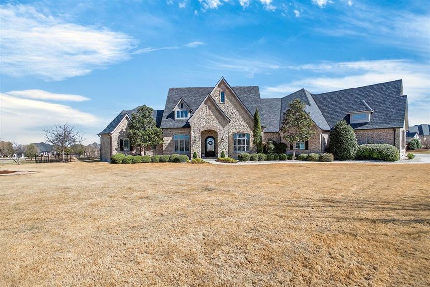 You won't want to miss this one! Come see this extraordinary private luxury estate on three acres in coveted La Madera within the award-winning Aledo Independent School District. Refined architecture and timeless craftsmanship define the home, highlighted by dramatic exposed wood beams, soaring ceilings, and expansive windows that frame sweeping views of the corner acreage. The open-concept design creates effortless flow between living spaces, ideal for both quiet relaxation and grand-scale entertaining. The chef’s kitchen serves as the heart of the home with an oversized island, premium finishes, abundant cabinetry, and generous prep space. The primary suite offers a spa-inspired bath and tranquil views, while secondary bedrooms and flexible spaces accommodate guests, home offices, or hobbies. A dedicated media room enhances entertainment possibilities and provides a versatile space for movie nights and gatherings. Outdoor living rivals resort-style amenities with a heated pool, expansive decking, and a huge covered area featuring a fireplace and outdoor kitchen. Wide-open Texas sunsets and privacy on a premium corner lot create a serene setting. Usable acreage allows for recreation and future customization, making the property adaptable to diverse lifestyles. A substantial heated and cooled custom shop adds exceptional functionality, ideal for luxury vehicle storage, RVs, workshop space, or professional use. Integrated storm shelter features provide added security and peace of mind. Gated community privacy combines with convenient access to town, schools, and amenities, offering the perfect balance of seclusion and accessibility. This estate blends luxury design with high-value functional amenities, delivering an exceptional lifestyle opportunity for discerning buyers seeking space, craftsmanship, and elevated living in one of Aledo’s most desirable communities.