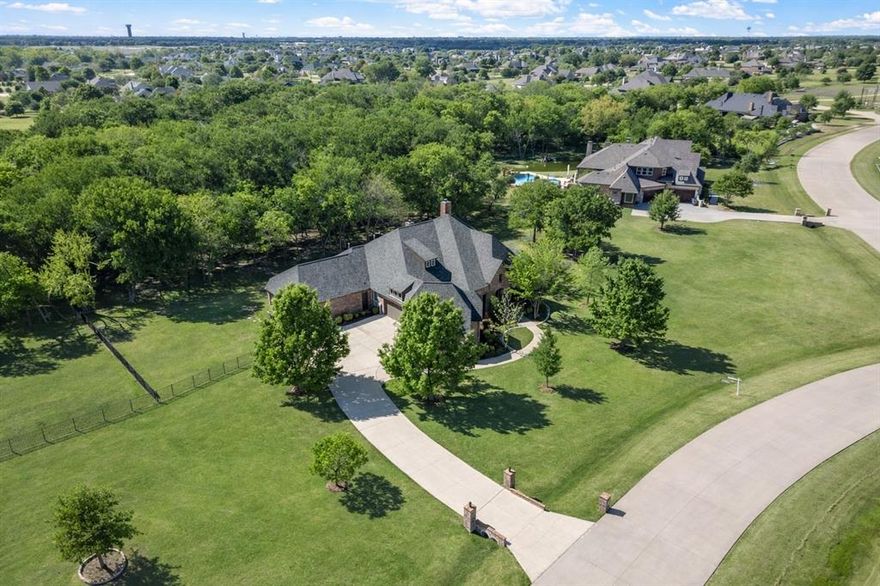 Tucked away on a quiet cul-de-sac street in highly sought-after Lovejoy ISD, this exceptional single-story estate offers a rare opportunity to own a private, acreage retreat without sacrificing proximity to everything you need.

Set on 2 beautifully treed acres with a serene wooded backdrop, the property immediately evokes a sense of calm, space, and seclusion - something increasingly difficult to find. Designed for both everyday comfort and elevated entertaining, the home unfolds with intention, offering expansive living spaces, soaring ceilings, and rich architectural detail throughout.

At the heart of the home, the main living area is anchored by a dramatic stone fireplace and framed by walls of windows that draw the outdoors in. The open-concept design flows effortlessly into the kitchen and dining spaces, creating an environment that feels both connected and refined.

Step outside and the experience continues. The backyard is a true extension of the home - complete with a sparkling pool, spa, and a covered patio featuring an outdoor fireplace and built-in grill. Whether hosting under the stars or enjoying a quiet evening at home, this space was designed to be lived in year-round.

With four spacious bedrooms (with en-suites) and thoughtfully designed private spaces, the home offers flexibility for multi-generational living, guests, or dedicated work-from-home environments - all without compromise.

For the discerning buyer, the five-car garage is a standout feature, offering not only ample storage but the ability to accommodate a boat or recreational vehicle - perfect for weekends at nearby Lake Lavon.

Opportunities like this are few and far between: a single-story home of this scale, on acreage, with amenities, in one of the area’s most coveted school districts.

This is more than a home - it’s a lifestyle. Schedule your private showing today!