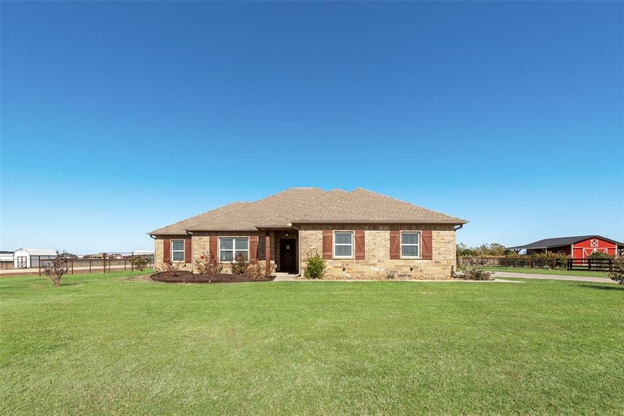 Welcome to this 4-bedroom, 2-bath brick and stone beauty perfectly set on a full acre in an highly rated school district. Nestled on a corner lot along a peaceful county road, this home offers the perfect blend of space, privacy, and small-town charm with pipe fencing enclosing the entire backyard. Step inside and fall in love with the open-concept floorplan, where the kitchen flows seamlessly into the family room, centered around a cozy wood burning fireplace. The split-bedroom layout provides comfort and privacy, while the spacious utility room offers abundant storage and cabinet space. The primary suite en-suite bath offers a double-vanity bath with jetted tub, separate tile shower, and a walk-in closet. Unwind under the covered back patio as you take in the breathtaking Texas sunsets, the perfect backdrop for grilling, entertaining, or simply relaxing after a long day. This property offers everything you’ve been searching for: acreage, charm, and convenience all wrapped up in one beautiful package. Frontier high speed internet available and no HOA, no MUD, no PID, NO CITY TAXES, just outside city limits.