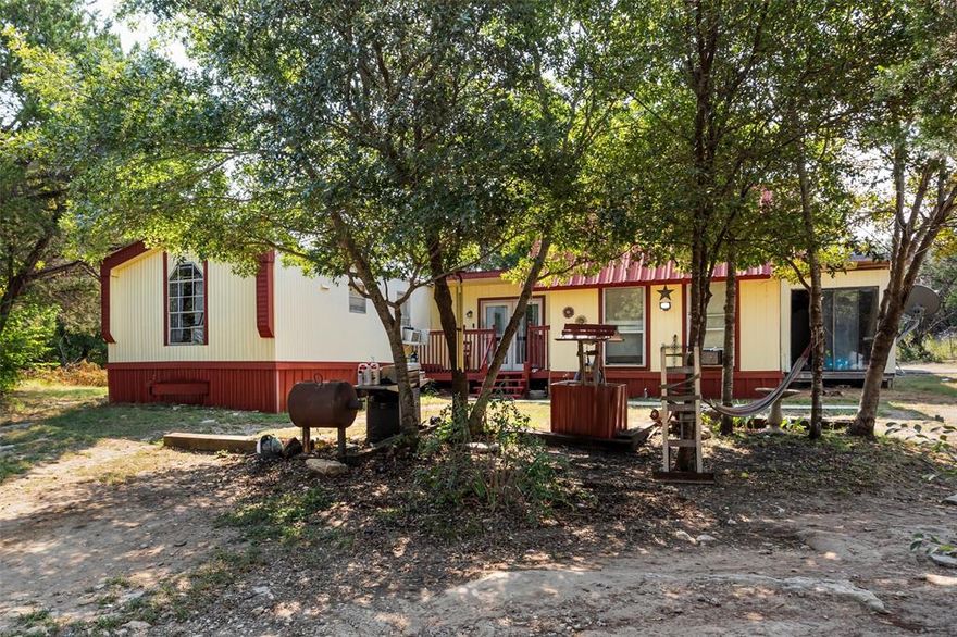 Tucked away among mature trees, 2719 River View Trail offers 3.107 acres across two parcels, providing complete seclusion and privacy. The property features a 1,320 sq ft residence, which includes a single-wide mobile home attached to a 300 sq ft structure, plus two additional cabins for guests, storage, or hobby use.
Being sold as-is, where-is, this property offers endless possibilities renovate, invest, or build new. With space for livestock, gardening, or outdoor recreation, and still just minutes from Lake Granbury, shopping, and schools, this unique property delivers both privacy and convenience.